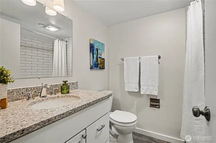 Main full size bathroom with ample counterspace and neutral color palate.