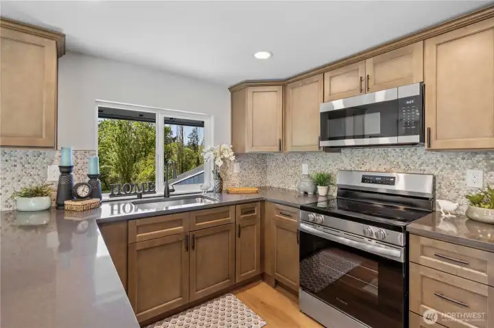 Kitchen w/New Cabinets w/Crown & Pulls. Quartz Counters, Stainless Steel Sink and Appliances.