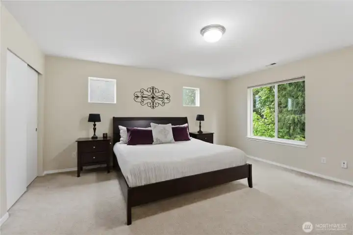 The peaceful and spacious primary suite looks out onto a greenbelt for a beautiful territorial view.