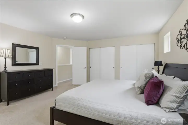The open light-filled primary suite has an abundance of closet space and storage.  Shown in this picture are double closets.  In the bathroom is an additional walk-in closet.