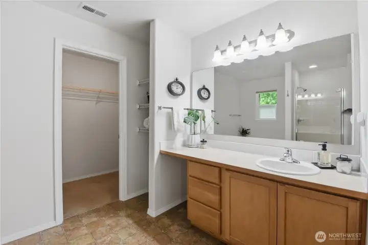 The primary has a large walk-in closet and also linen storage to the left of the vanity.