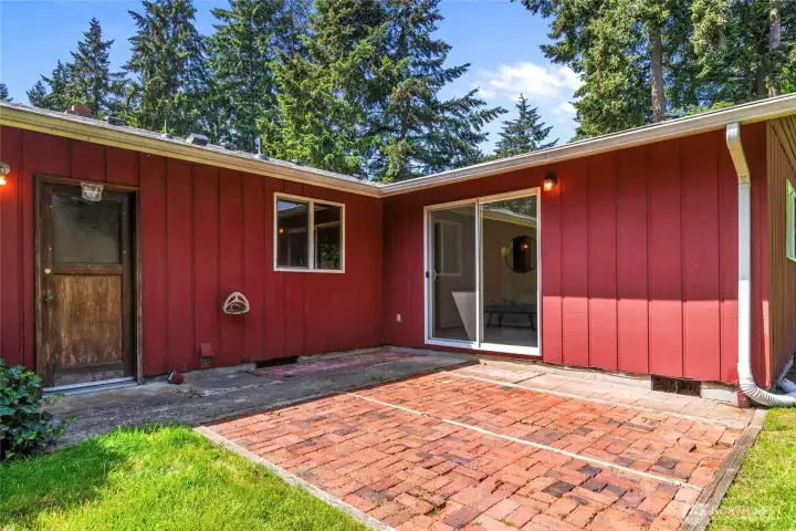 Backyard patio with entrance from primary bedroom and the attached garage Backyard patio with entrance from primary bedroom and the attached garage