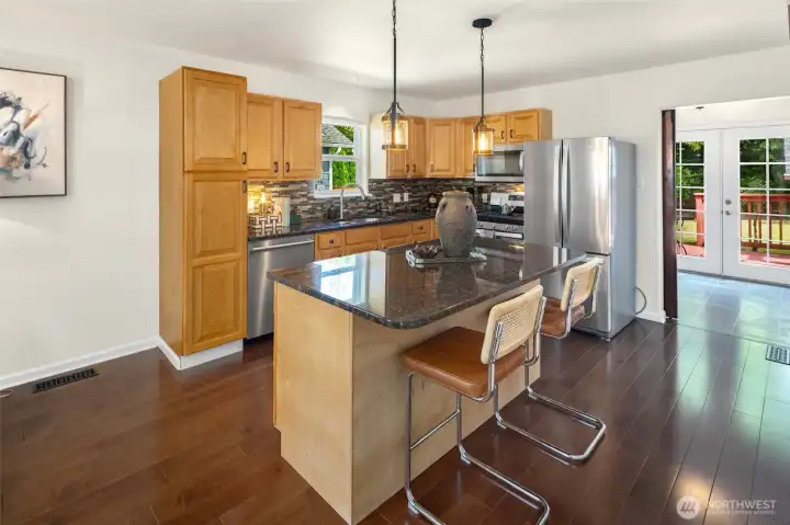 Updated kitchen with granite countertops, stainless steel appliances, and a spacious island with seating. Updated kitchen with granite countertops, stainless steel appliances, and a spacious island with seating.