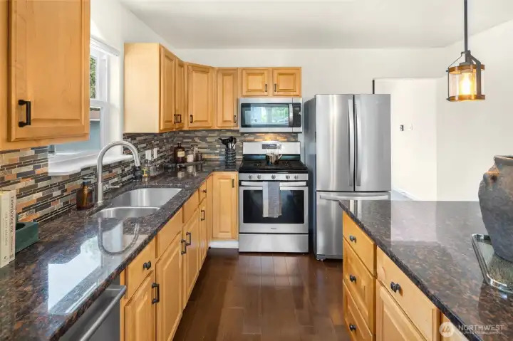 The kitchen features a gas range for home chefs, a large island for gathering, and a sink perfectly positioned beneath a window overlooking the yard. The kitchen features a gas range for home chefs, a large island for gathering, and a sink perfectly positioned beneath a window overlooking the yard.