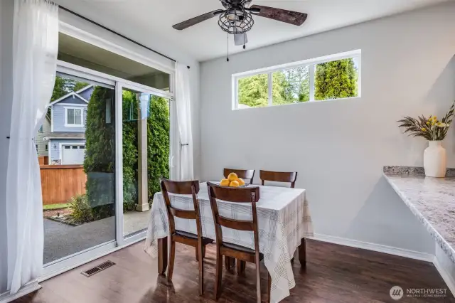 This bright and inviting breakfast nook features direct access to the backyard through sliding glass doors, offering the perfect spot for casual dining with seamless indoor-outdoor flow.