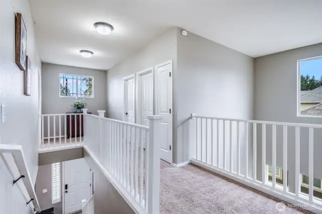 The second level features a bright and airy landing area with a convenient linen closet, overlooking the living room and adding to the home's open and spacious feel.