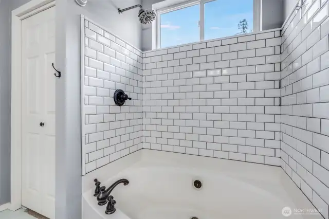 Relax and unwind in the luxurious soaking shower-tub combo, featuring a sleek tile surround and elegant fixtures for a spa-like retreat in the primary bathroom.