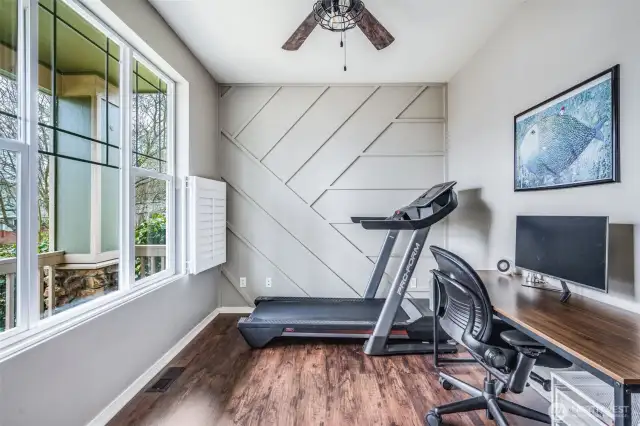 Designed for both productivity and style, this office features elegant French doors, a striking accent wall, plantation shutters, and durable laminate wood flooring—creating a bright and functional workspace.