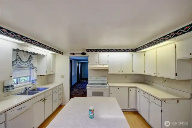 Bright, oversized kitchen with white cabinetry and plenty of counter space