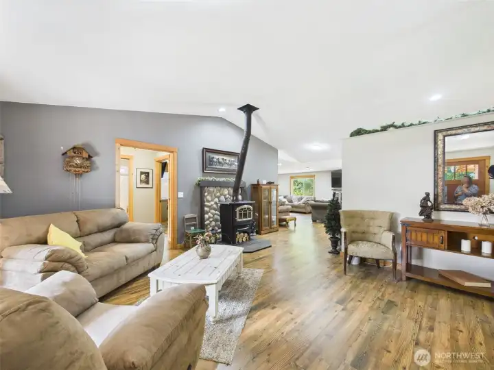 Living room with vaulted ceilings  and wood stove with rock surround.
