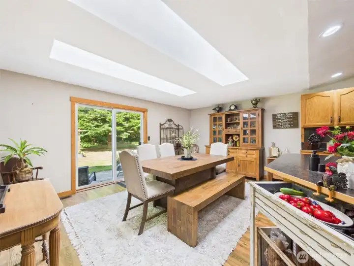 Dining room with slider to the back patio. Lots of natural light with vaulted ceilings and skylights.