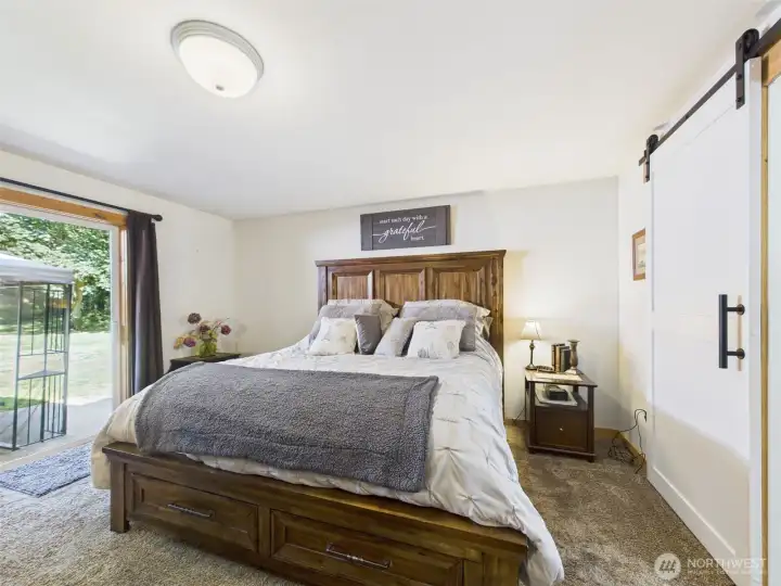 Primary bedroom with slider leading to back patio and hot tub area.
