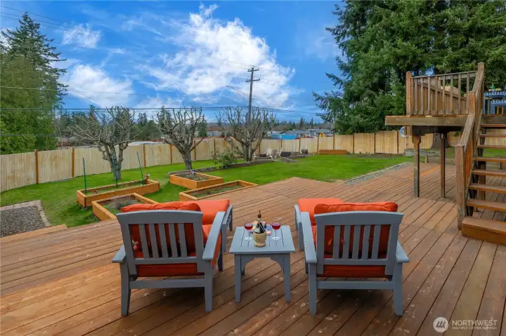 Whether you're sipping your morning coffee, BBQing with friends, unwinding with a book, or watching the sunset after a long day, this deck is the perfect place to experience it all. All 3 Levels of the Deck are spaciously-designed and look out over the beautiful backyard. This middle deck is ~18x21.