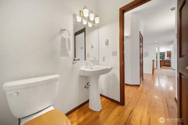 Powder Bath with wood flooring and pedestal sink.