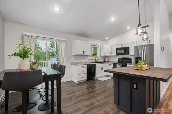 A beautifully designed kitchen pairs crisp white cabinetry with a striking dark wood peninsula creating a timeless contrast that feels both elegant and inviting.