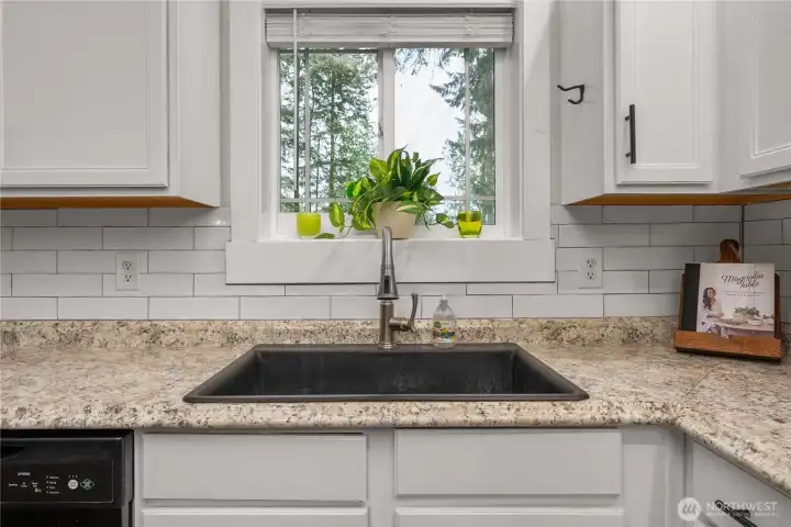 A pretty window above the sink gives a view of the lush green yard.