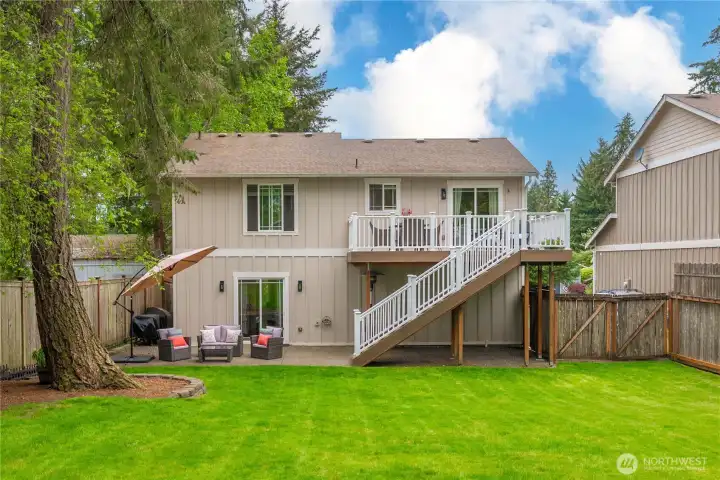 The back of the home presents a beautifully designed outdoor living space with multiple levels for relaxing and entertaining.