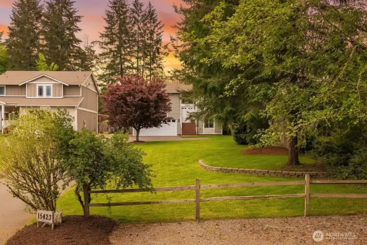 Thoughtfully designed landscape with neatly edged curved borders frames the home with texture and dimension throughout the yard.
