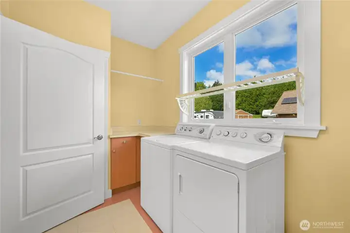 Laundry room just inside garage with lots of storage space
