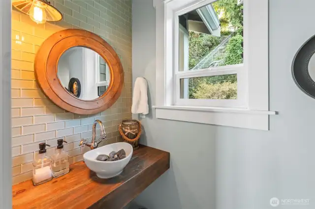 This powder room has the perfect touch - with seaglass inspired subway tile and solid wood counter