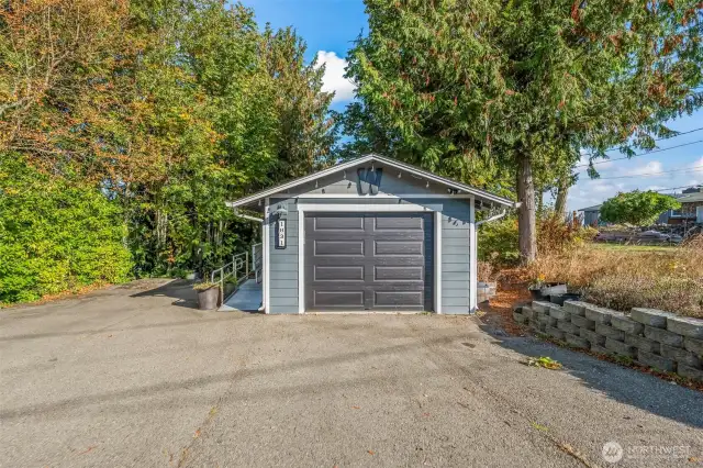 There is a very large driveway with abundant parking and a free standing one-car garage with storage space