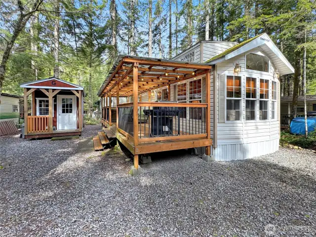 2013 Quailridge Park Model sits on a sunny lot with storage shed.