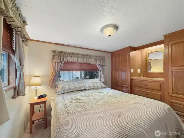Primary bedroom has built-in storage and a queen size bed.