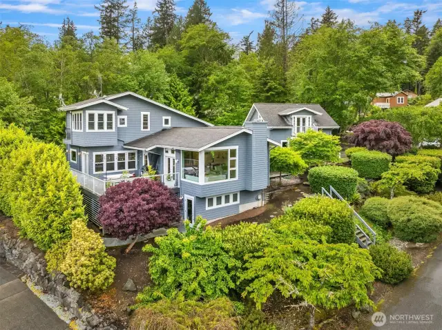 Beautifully landscaped with easy care bushes and tress this home sits almost at the end of a quiet cul-de-sac. The grey shingled structure to the right is part of the main home connected in the interior.