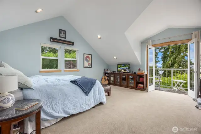 The second upper level bedroom is located in the other wing of the home accessed from stairs off the main entryway. All bedrooms enjoy a balcony or deck access as well as an en-suite bath. This room also has a home office work space included- out of sight to the right in this photo.