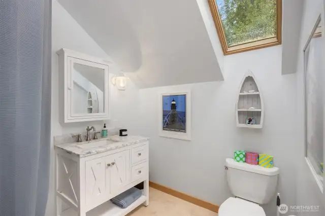 The en-suite off the upper level bedroom has a skylight to bring in natural light.