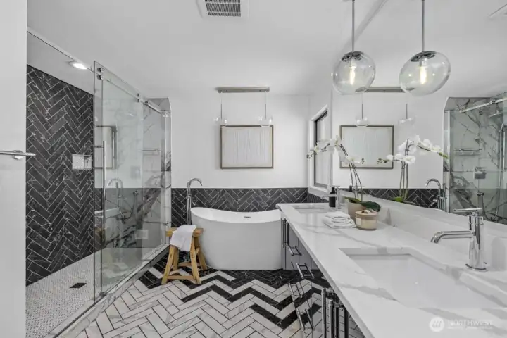 This spa-inspired bath features a large tub, spacious shower with two rain shower heads, and plenty of storage.