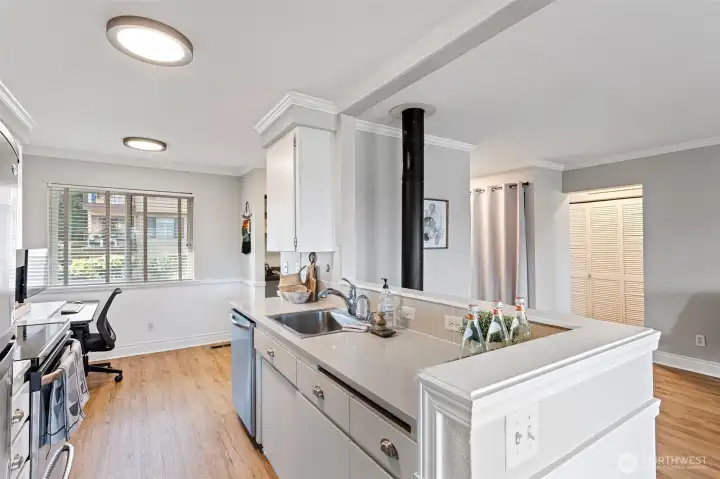 The open kitchen plan facilitates interaction and conversational flow. Notice the modern upgrades: Quartz counters, light fixtures and instant hot water dispenser!