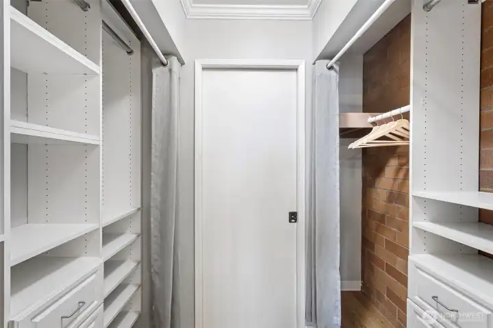 The primary bedroom’s large walk-through closet is flanked on both sides with custom built-ins that keep the wardrobe organized.
