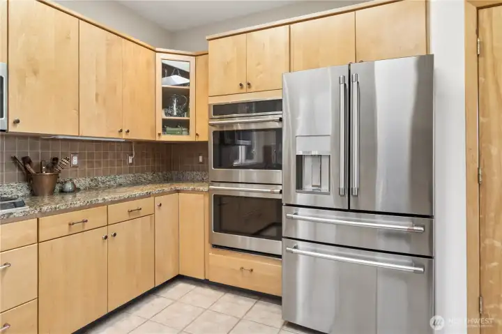 Double oven and French door refrigerator. Pantry closet door to the right.