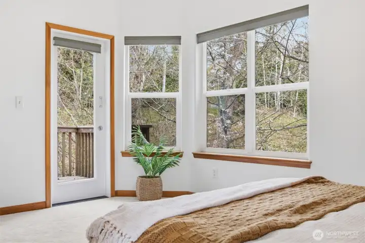 The primary suite opens to the rear deck where one can take in nature.