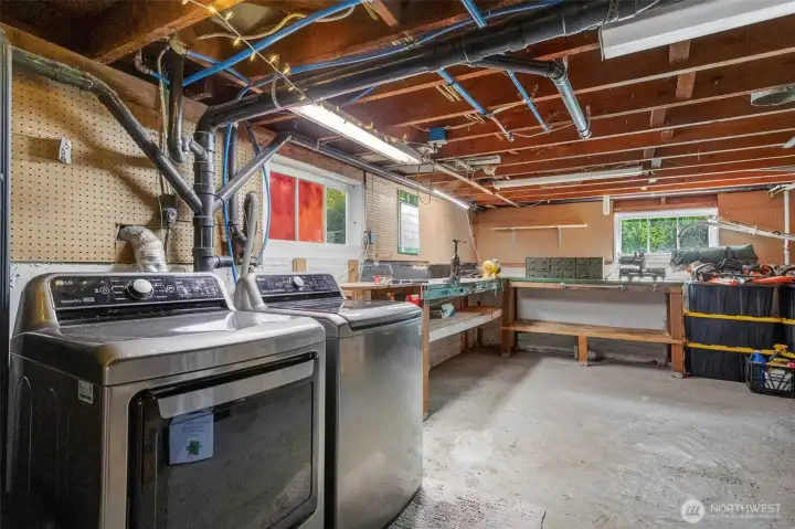 Basement features a laundry area with washer & dryer, along with a spacious workshop area.