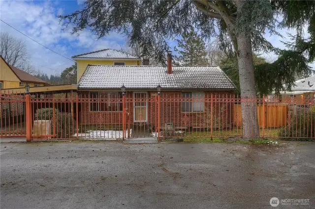 Fun wrought iron fence allows the charm of the home to peek through.