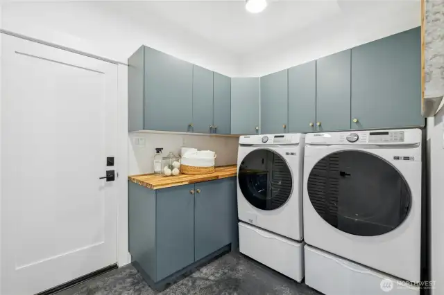 The main floor, fully equipped laundry room with a Samsung front-loading washer & dryer with pedestals and terrific storage cabinetry. The laundry room connects directly to the 2-car garage with a Charge Point EV-charger already installed.