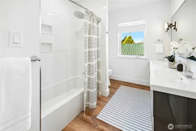 The full hallway bathroom upstairs with a tiled shower/tub combo with Grohe faucet, dual sinks with Kohler faucets, Kohler toilet.