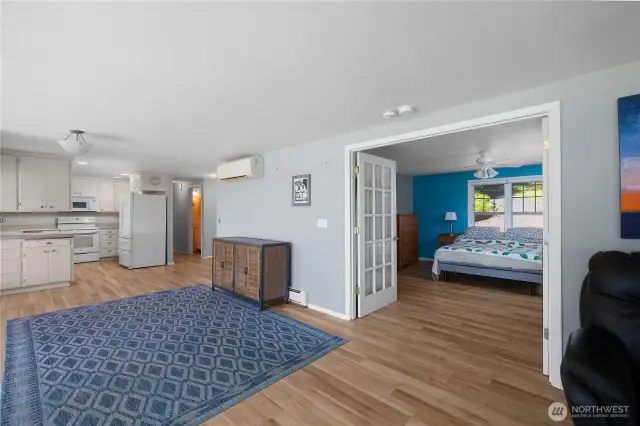 Living room with view of primary bedroom with french doors for view