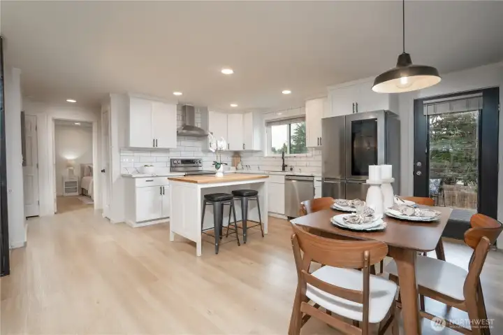 Open kitchen-dining space with modern finishes, cozy lighting, and natural wood tones.