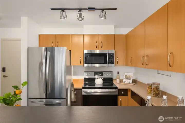 Contemporary cabinets provide plenty of storage space. Track lighting in kitchen is chef's delight!