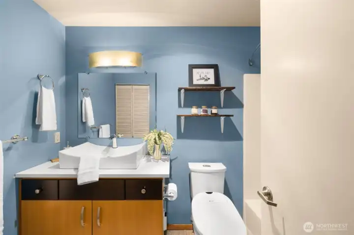 The modern bathroom features sleek fixtures & oversized sink.