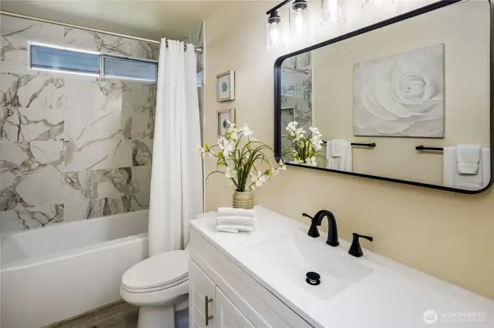 Beautifully updated bathroom...new everything...vanity, faucet, mirror, tub/shower, paint, flooring and lighting!