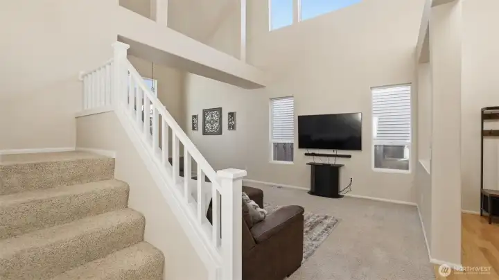 Spacious front living area featuring tall ceilings, soft carpeting, and an open layout perfect for everyday living.