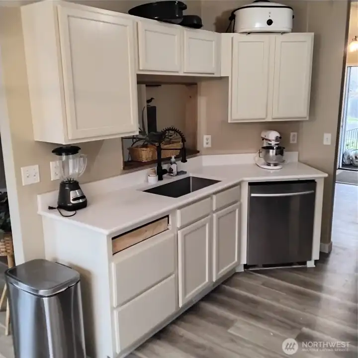 Kitchen has new countertop, back splash, and stainless steel sink