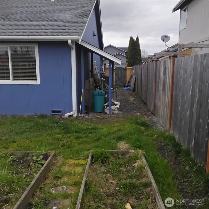 Side of the house has an overhang area for storage.