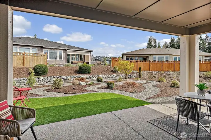 The covered patio frames Mt Rainier - The landscaped backyard - a rock retaining wall & artificial turf