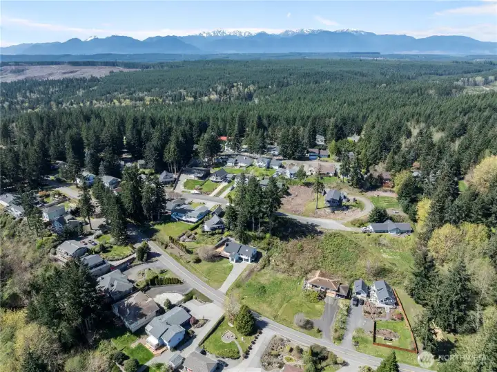 Aerial shot capturing the beautiful Pacific Northwest landscape and mountain silhouettes in the distance.