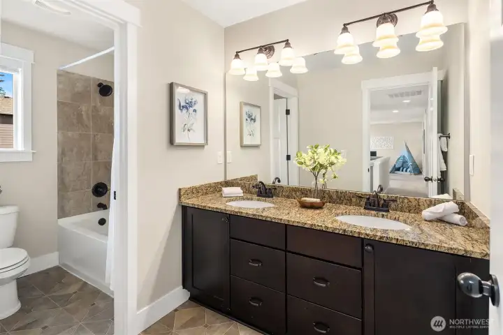 Hall bath with double vanity and separate tub and toilet space